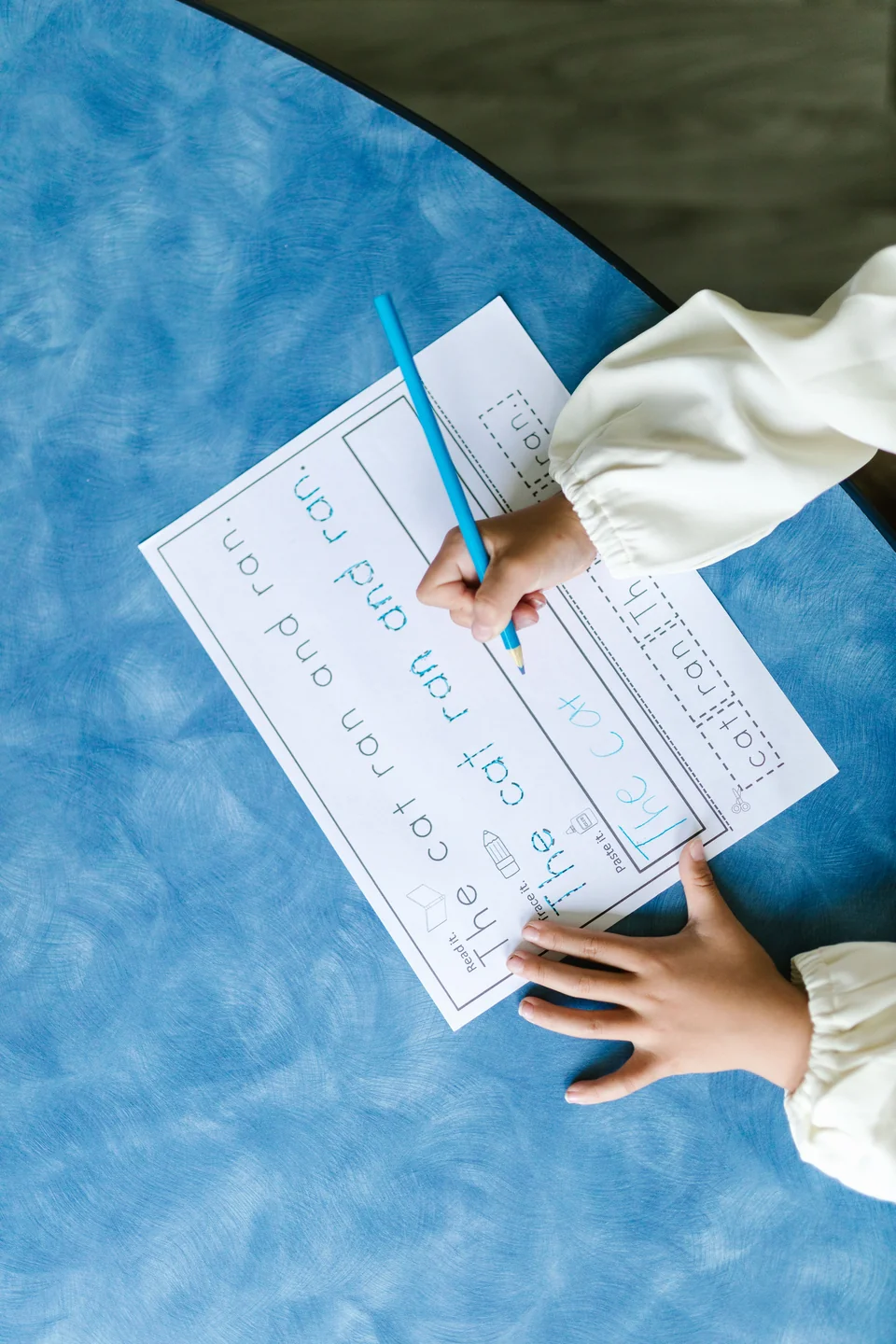 Anak menulis dengan pensil di buku latihan